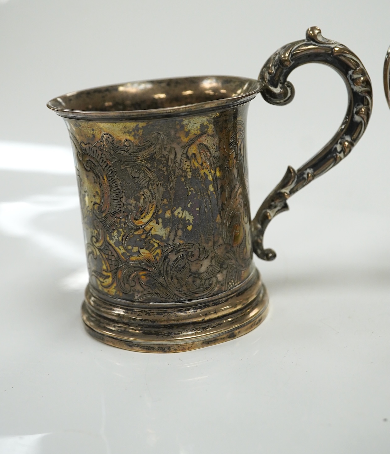 A George V Brittania standard silver kitchen pepper, by John Charles Lowe, London, 1935, 11.5cm and a Victorian silver christening mug, 10.4oz. Condition - poor to fair